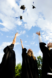 Image of students and graduation caps in the air.